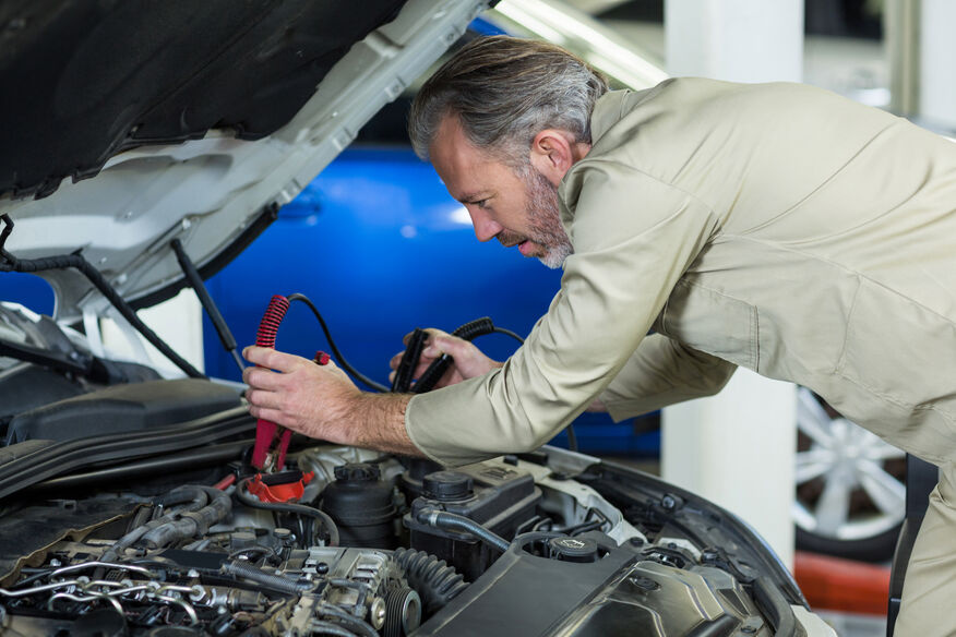 mechanic-attaching-jumper-cables-car-battery