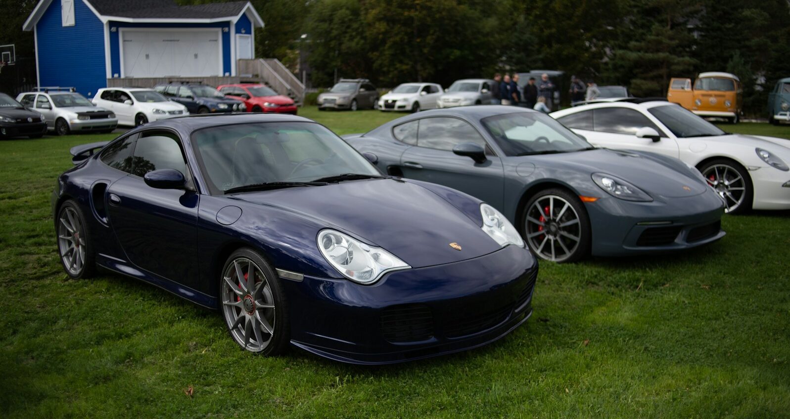 black porsche 911 parked on green grass field during daytime