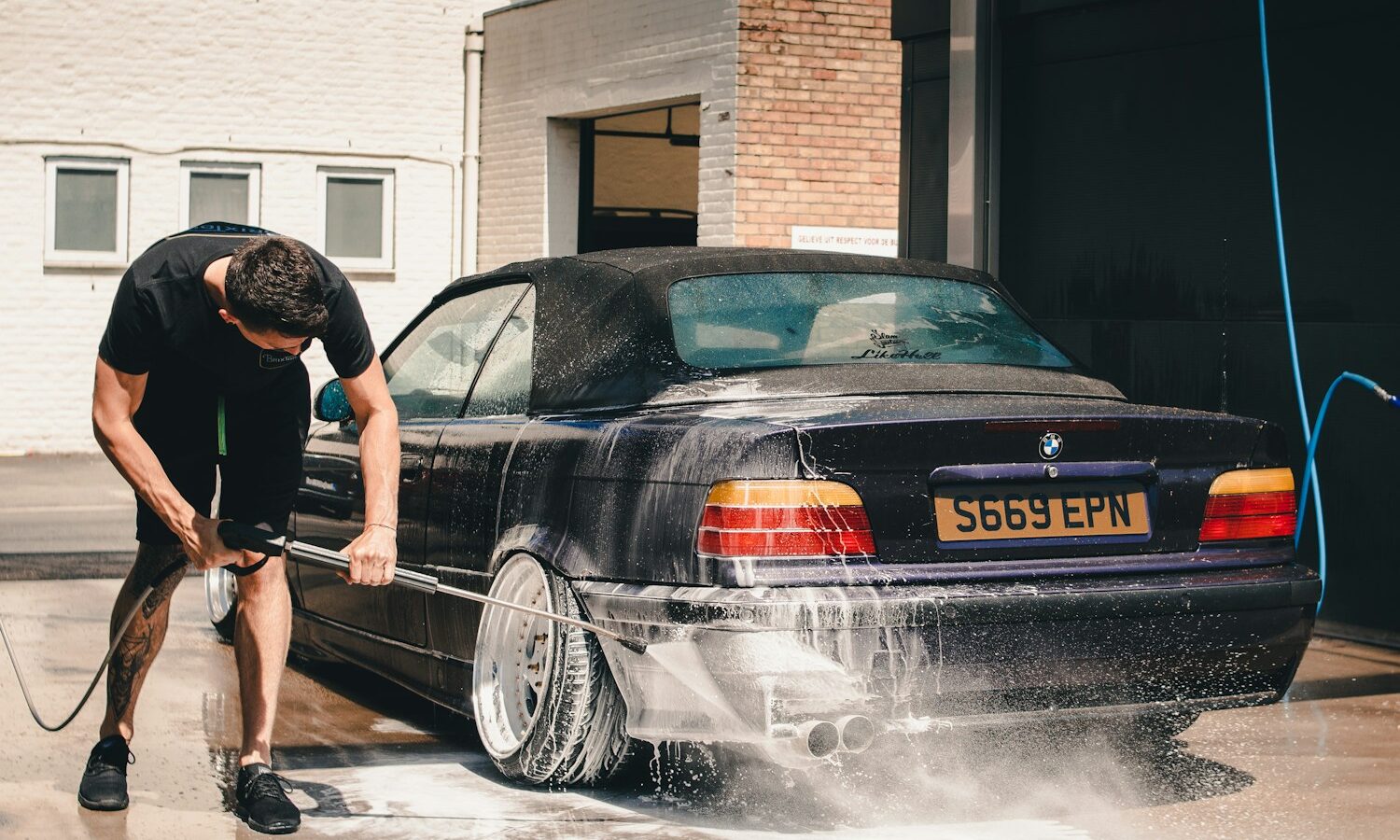 man washing BMW coupe